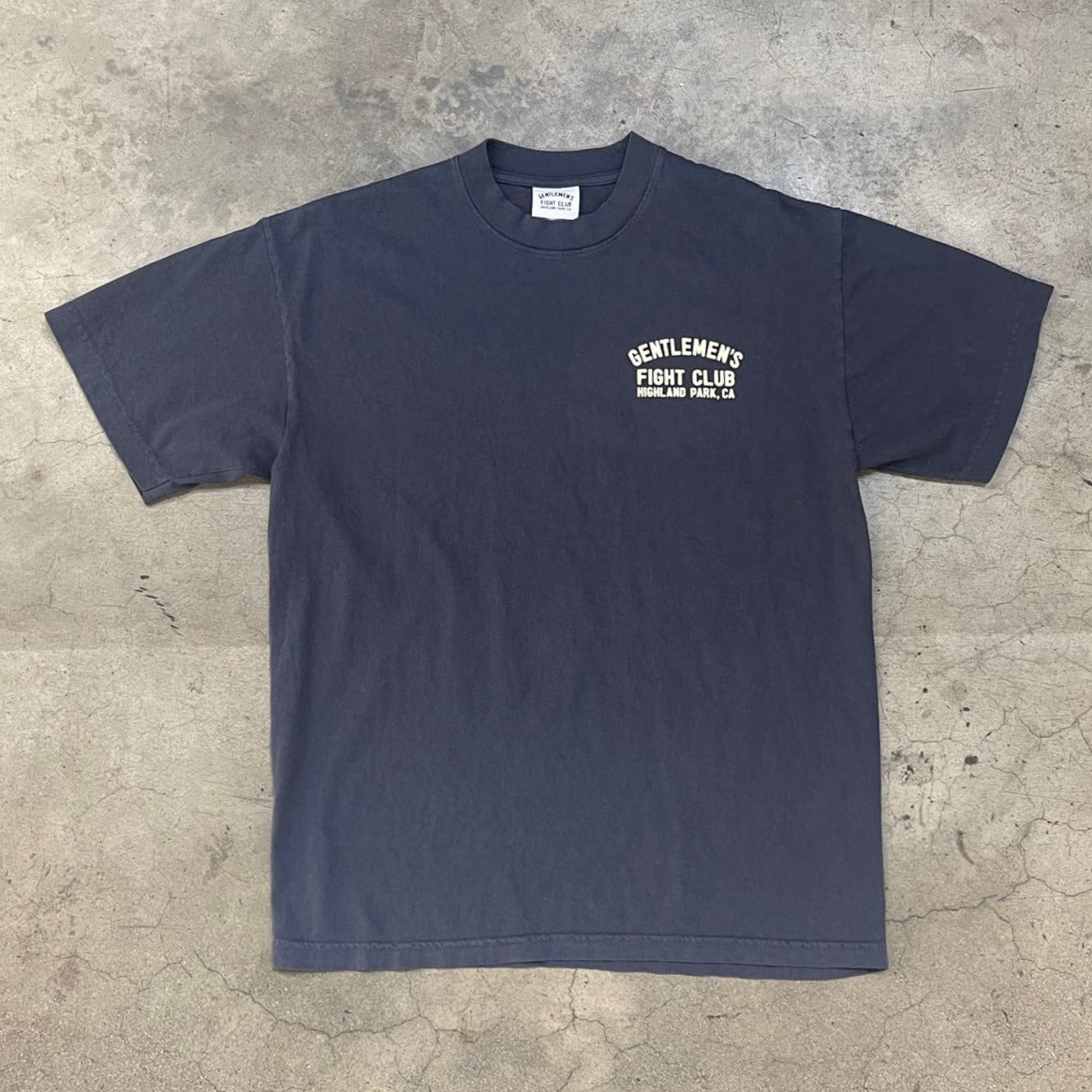 Front of dusty navy tee with creme print that reads "Gentlemen's Fight Club Highland Park, CA"