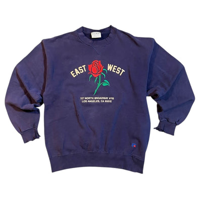 Navy blue sweatshirt with a rose graphic and text on a white background