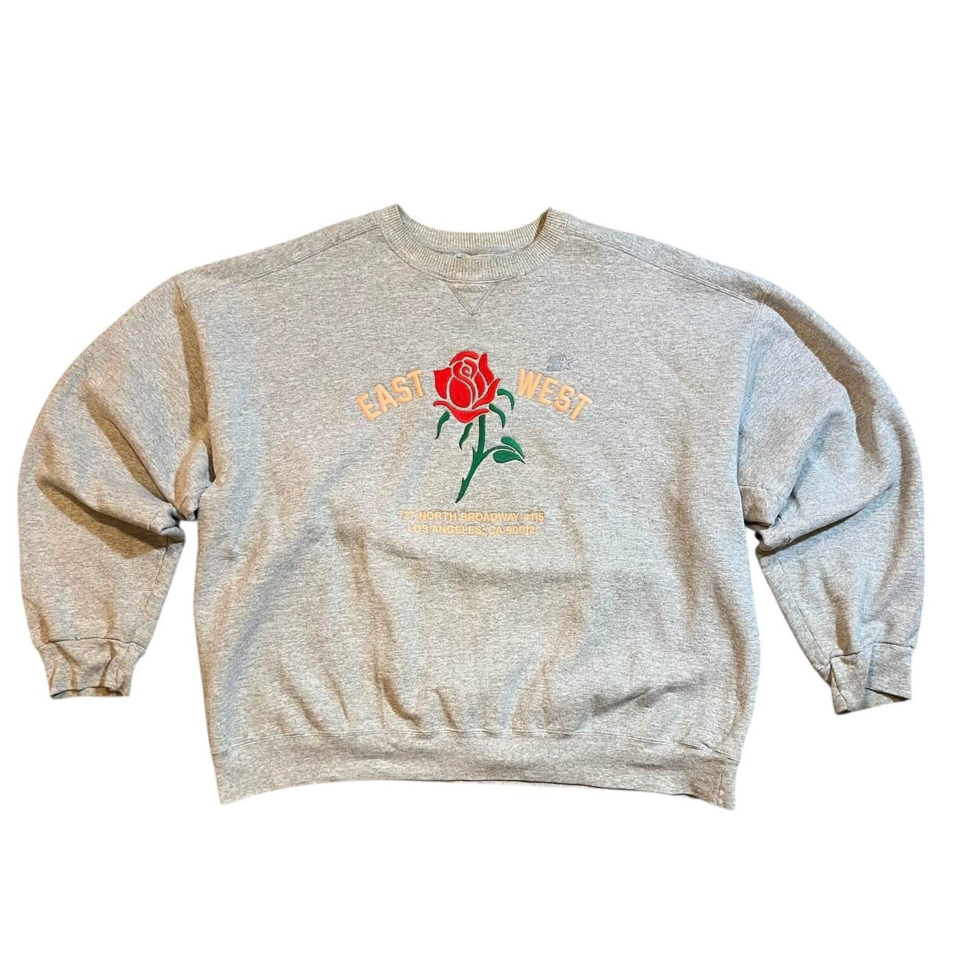 Gray sweatshirt with a rose graphic and text on a white background
