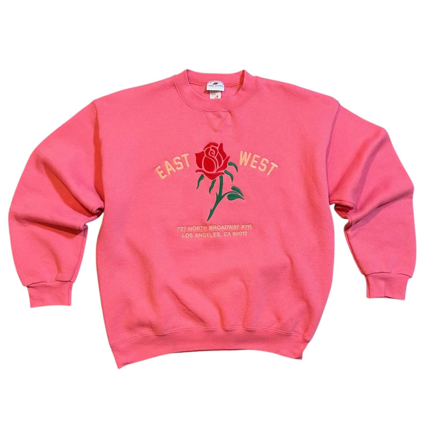 Pink sweatshirt with a red rose graphic and text on a white background