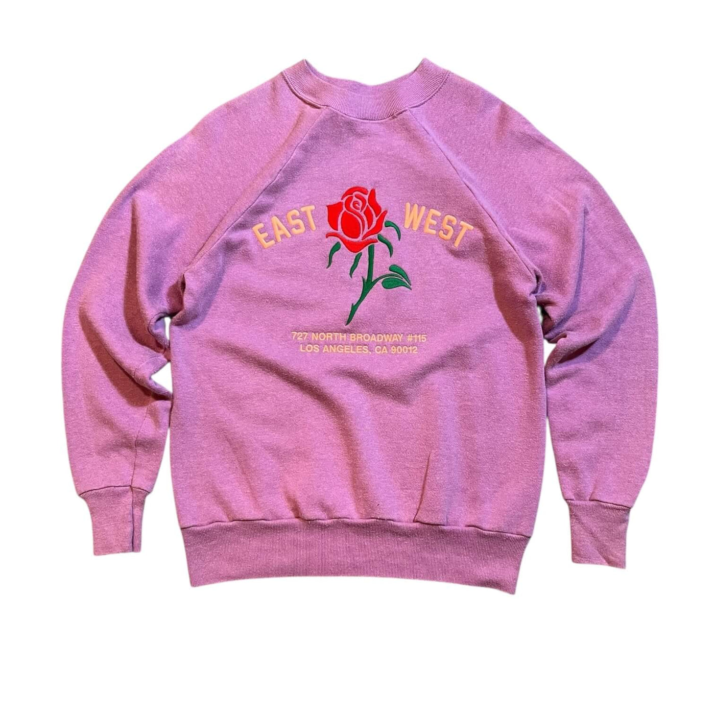 Pink sweatshirt with a rose graphic and text on a white background